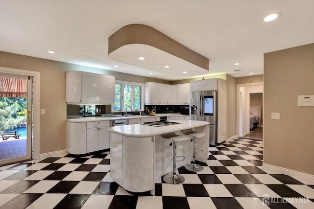 403 New Dover Rd, Colonia, NJ 07067 - kitchen featuring light countertops, stainless steel fridge, tile patterned floors, a kitchen island, and a breakfast bar area