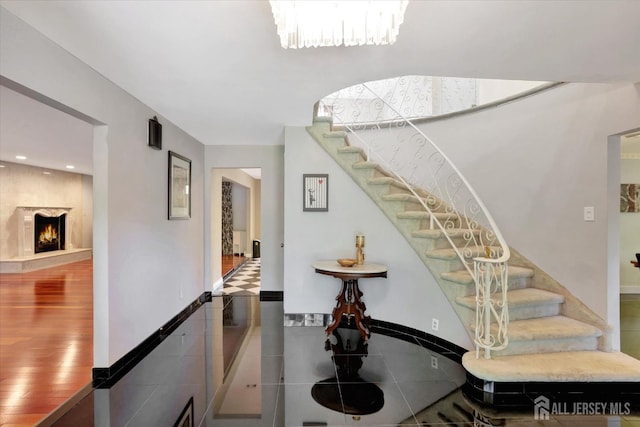 403 New Dover Rd, Colonia, NJ 07067 - stairway with tile patterned floors, a lit fireplace, recessed lighting, and a chandelier