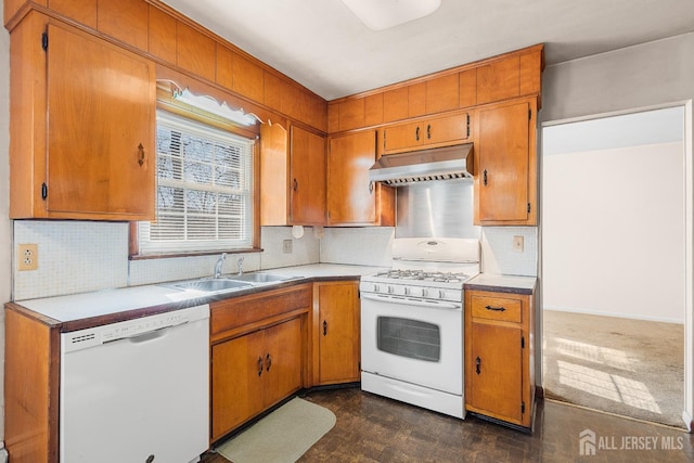 kitchen with white appliances, brown cabinets, light countertops, a sink, and exhaust hood