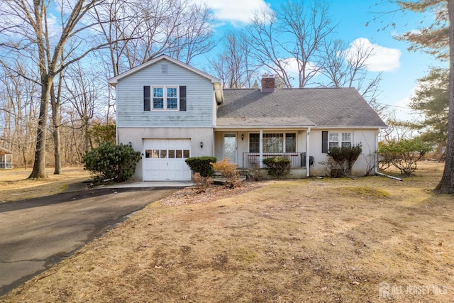 view of front facade featuring a garage, a front lawn, and covered porch