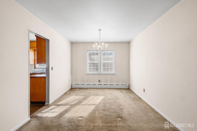 carpeted empty room featuring baseboards, a baseboard heating unit, a chandelier, and a sink