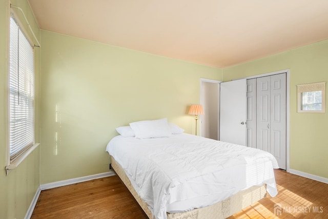 bedroom featuring a closet, baseboards, and wood finished floors