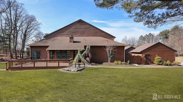 view of front of property with a shingled roof, a front yard, and a wooden deck