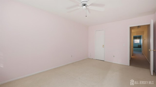 unfurnished bedroom with light carpet, a ceiling fan, and baseboards