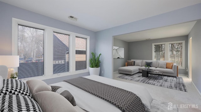 carpeted bedroom with baseboards, multiple windows, and visible vents