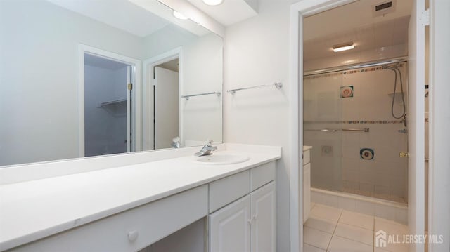 bathroom featuring tile patterned floors, a shower stall, visible vents, and vanity