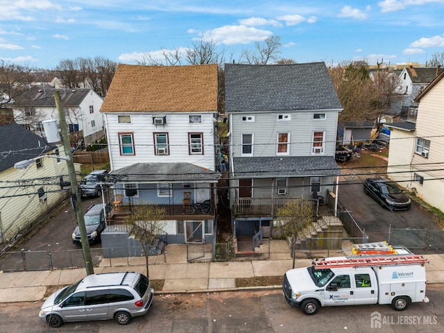 188 Seaman St, New Brunswick, NJ 08901 - view of front of home featuring stairs, a shingled roof, a fenced front yard, and a residential view