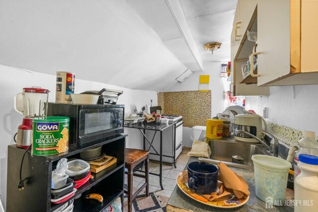 188 Seaman St, New Brunswick, NJ 08901 - kitchen featuring a sink, white range with gas cooktop, lofted ceiling, black microwave, and light tile patterned floors