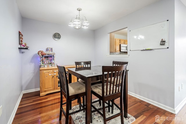 dining area featuring a notable chandelier and dark hardwood / wood-style flooring