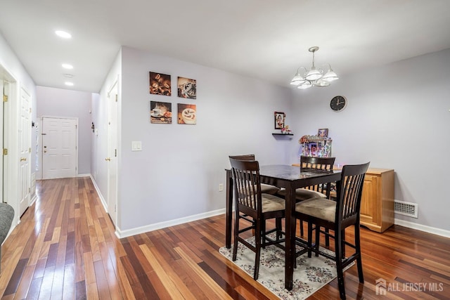 dining area featuring dark hardwood / wood-style flooring and a chandelier