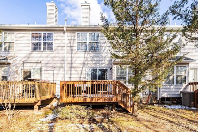 rear view of house with central AC and a deck