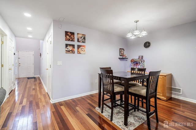 dining room featuring dark hardwood / wood-style floors and a chandelier