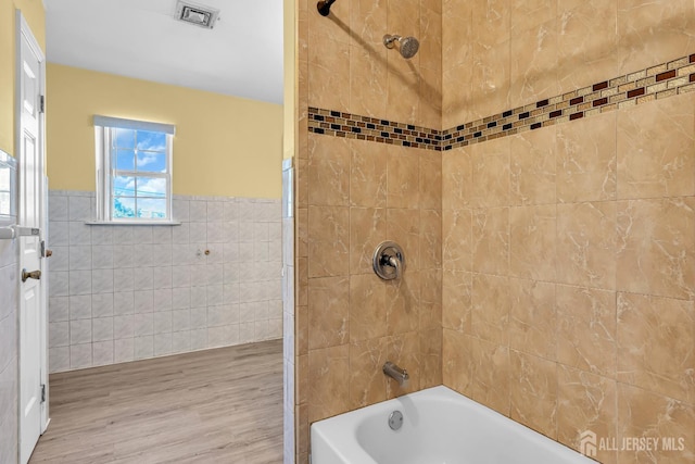 30 Montague Ave, Woodbridge Proper, NJ 08830 - bathroom with tile walls, wood finished floors, shower / washtub combination, and a wainscoted wall