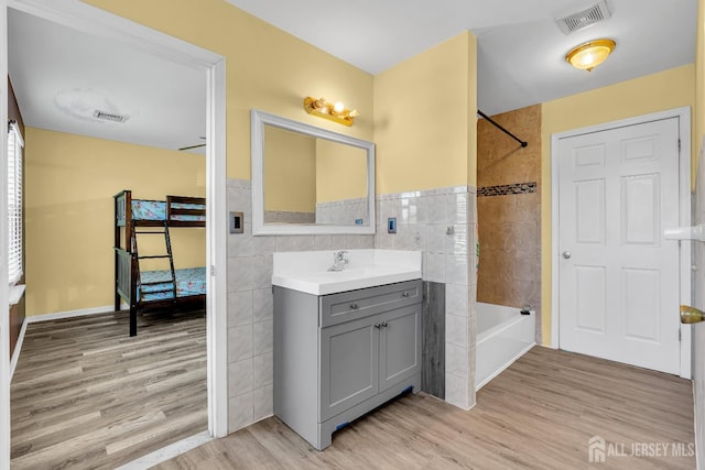 30 Montague Ave, Woodbridge Proper, NJ 08830 - bathroom featuring vanity, bathtub / shower combination, wood finished floors, and tile walls