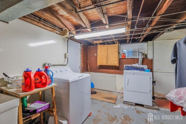 clothes washing area with laundry area, independent washer and dryer, and a sink