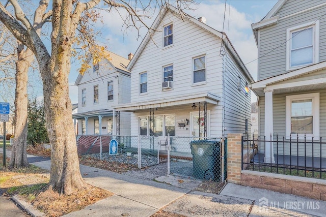 view of front of home featuring covered porch, a fenced front yard, cooling unit, and a gate