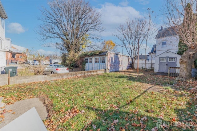 view of yard featuring an outbuilding, a shed, and a residential view