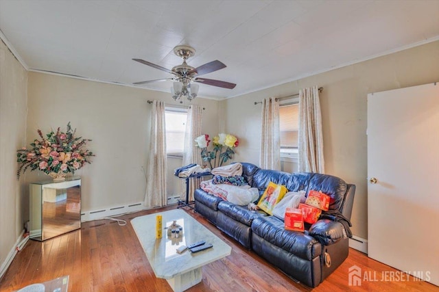 living room with ceiling fan, baseboard heating, wood finished floors, and crown molding