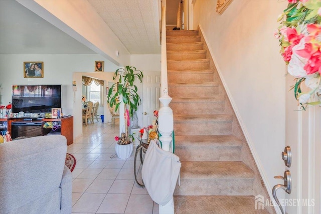 stairs featuring tile patterned flooring and baseboards