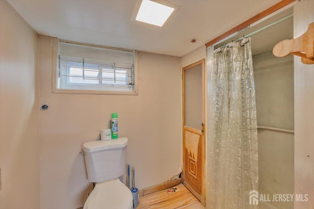 full bathroom with toilet and a shower with shower curtain