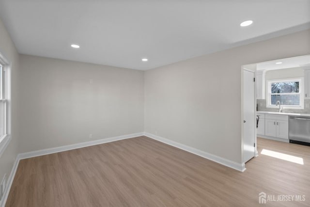 unfurnished room with light wood finished floors, recessed lighting, and baseboards