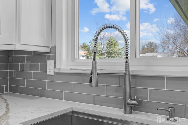 91 Dogwood Plz Unit A, Monroe, NJ 08831 - kitchen view of backsplash, white cabinetry, light stone counters, and a sink