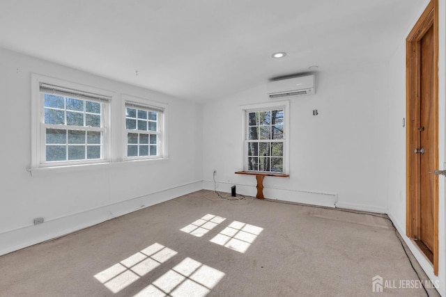 carpeted spare room featuring plenty of natural light, recessed lighting, a wall unit AC, and vaulted ceiling