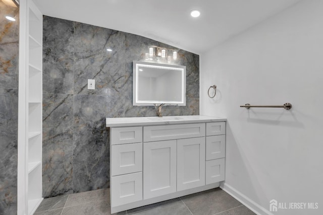 bathroom with tile patterned flooring, recessed lighting, vanity, and tile walls