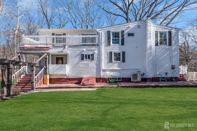 back of property with a deck, stairs, a yard, and ac unit