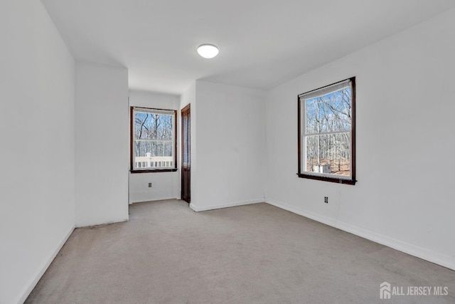 carpeted spare room featuring baseboards