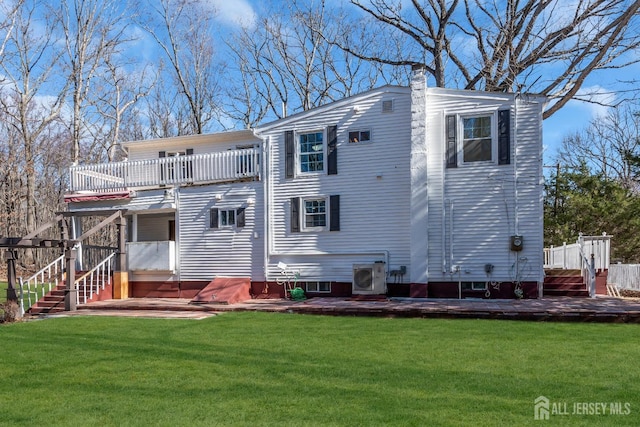 back of house featuring a deck, ac unit, a yard, and a chimney