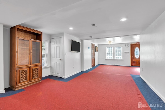 interior space featuring baseboards, carpet floors, and visible vents