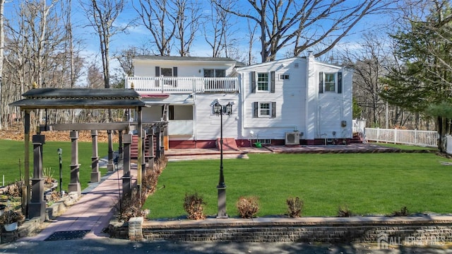 view of front facade with a front yard, central air condition unit, and fence