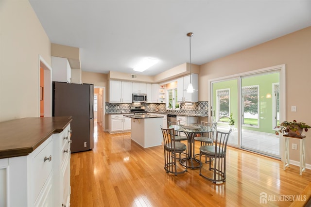 18 Stout Dr, Hillsborough, NJ 08844 - kitchen with stainless steel appliances, tasteful backsplash, dark countertops, light wood-type flooring, and white cabinetry