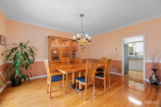 18 Stout Dr, Hillsborough, NJ 08844 - dining space featuring light wood finished floors, a chandelier, and ornamental molding