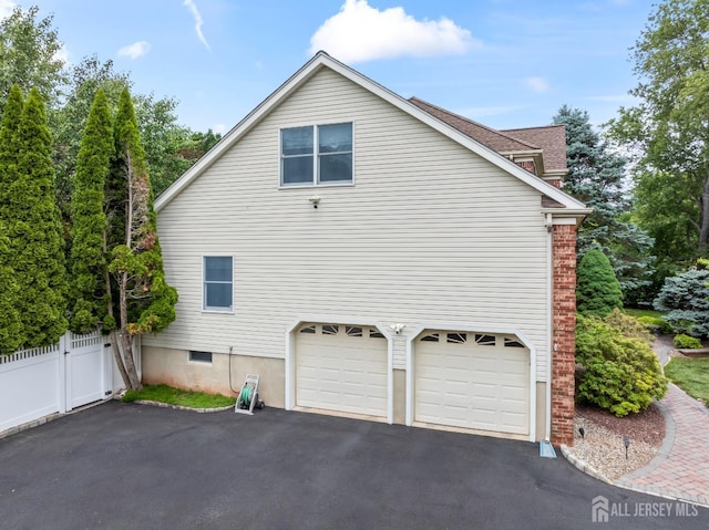18 Stout Dr, Hillsborough, NJ 08844 - view of side of home featuring driveway, an attached garage, and brick siding