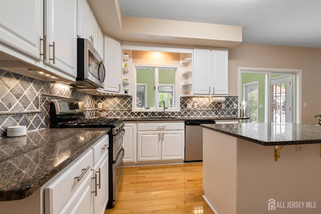 18 Stout Dr, Hillsborough, NJ 08844 - kitchen with appliances with stainless steel finishes, open shelves, a kitchen breakfast bar, light wood-type flooring, and white cabinets