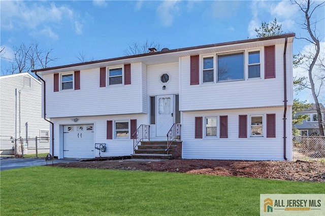 raised ranch featuring a front lawn, an attached garage, fence, and aphalt driveway