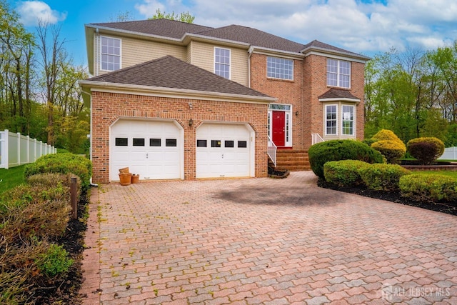 24 Chesapeake Rd, South Brunswick, NJ 08852 - traditional home featuring roof with shingles, fence, brick siding, a garage, and decorative driveway