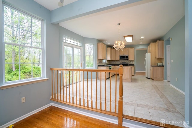 24 Chesapeake Rd, South Brunswick, NJ 08852 - kitchen with freestanding refrigerator, a notable chandelier, a healthy amount of sunlight, and stainless steel microwave