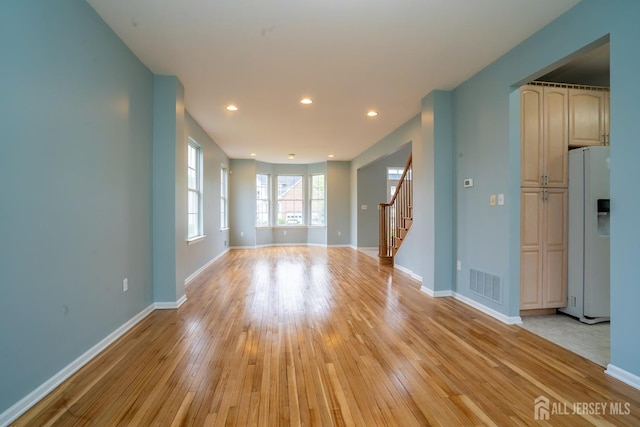 24 Chesapeake Rd, South Brunswick, NJ 08852 - unfurnished living room featuring baseboards, stairway, light wood finished floors, and visible vents