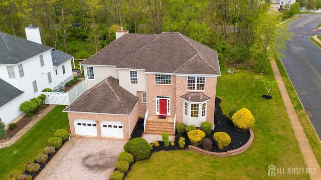 24 Chesapeake Rd, South Brunswick, NJ 08852 - view of front facade featuring driveway, brick siding, fence, an attached garage, and a front lawn