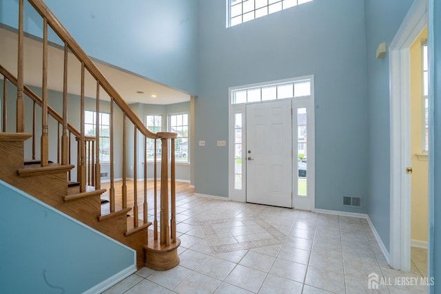 24 Chesapeake Rd, South Brunswick, NJ 08852 - foyer entrance with baseboards, visible vents, tile patterned flooring, stairway, and a high ceiling