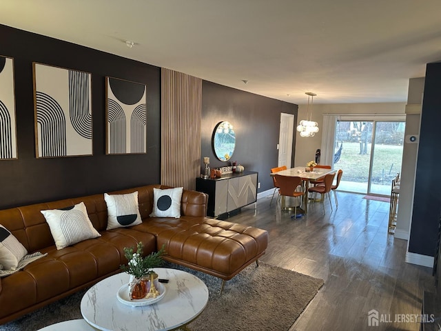 living room with dark hardwood / wood-style flooring and an inviting chandelier