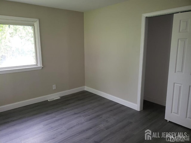 unfurnished room featuring dark wood-type flooring