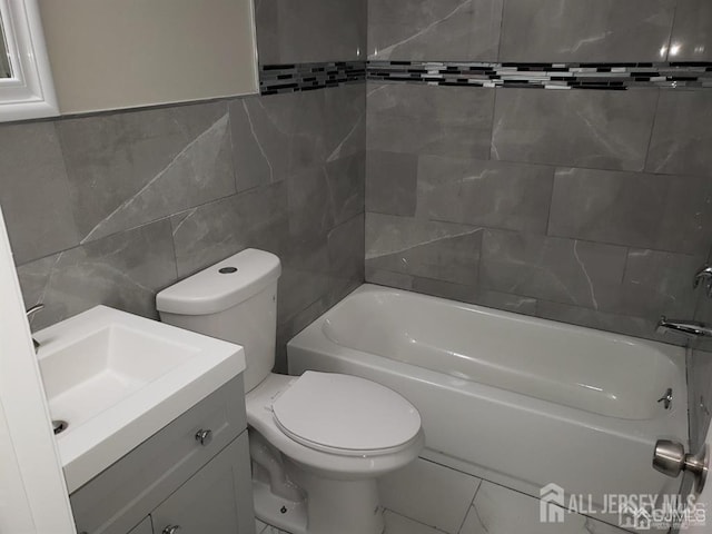 full bathroom with vanity, bathtub / shower combination, tile walls, and toilet