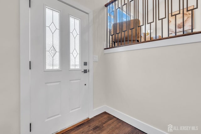 doorway featuring baseboards and dark wood finished floors