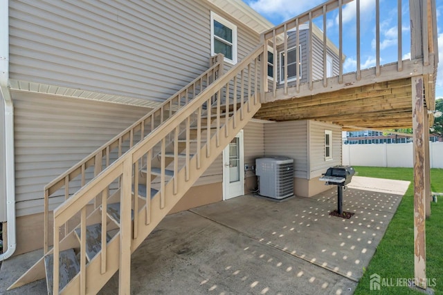 view of patio / terrace with central air condition unit, stairway, fence, and grilling area
