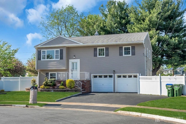 split foyer home featuring asphalt driveway and an attached garage
