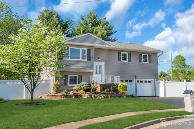 bi-level home with asphalt driveway and a garage